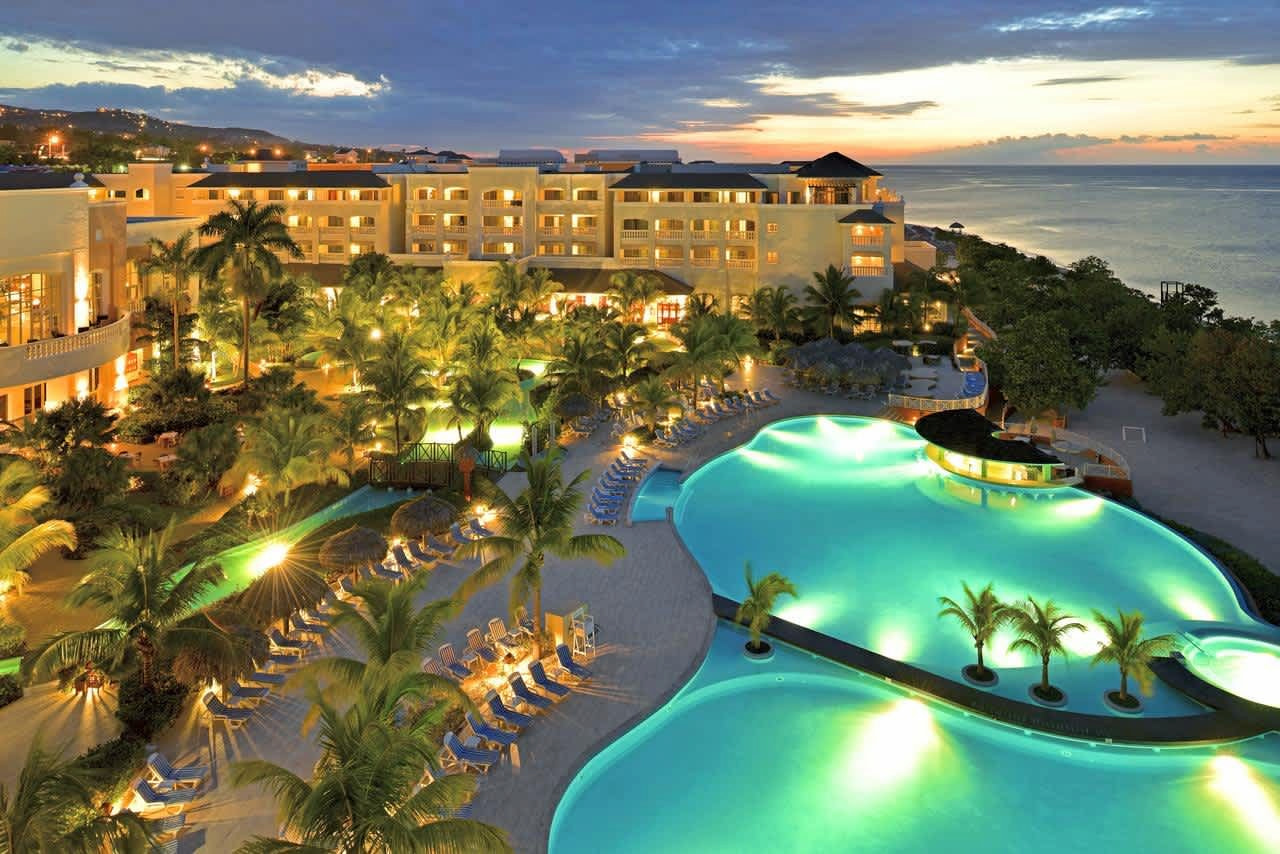Fachada y piscina con vistas al mar iluminado de noche del hotel Iberostar Rose Hall - Ejecución de las instalaciones y Mantenimiento realizado